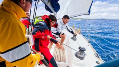 Equipaggio al lavoro nel pozzetto di una barca a vela